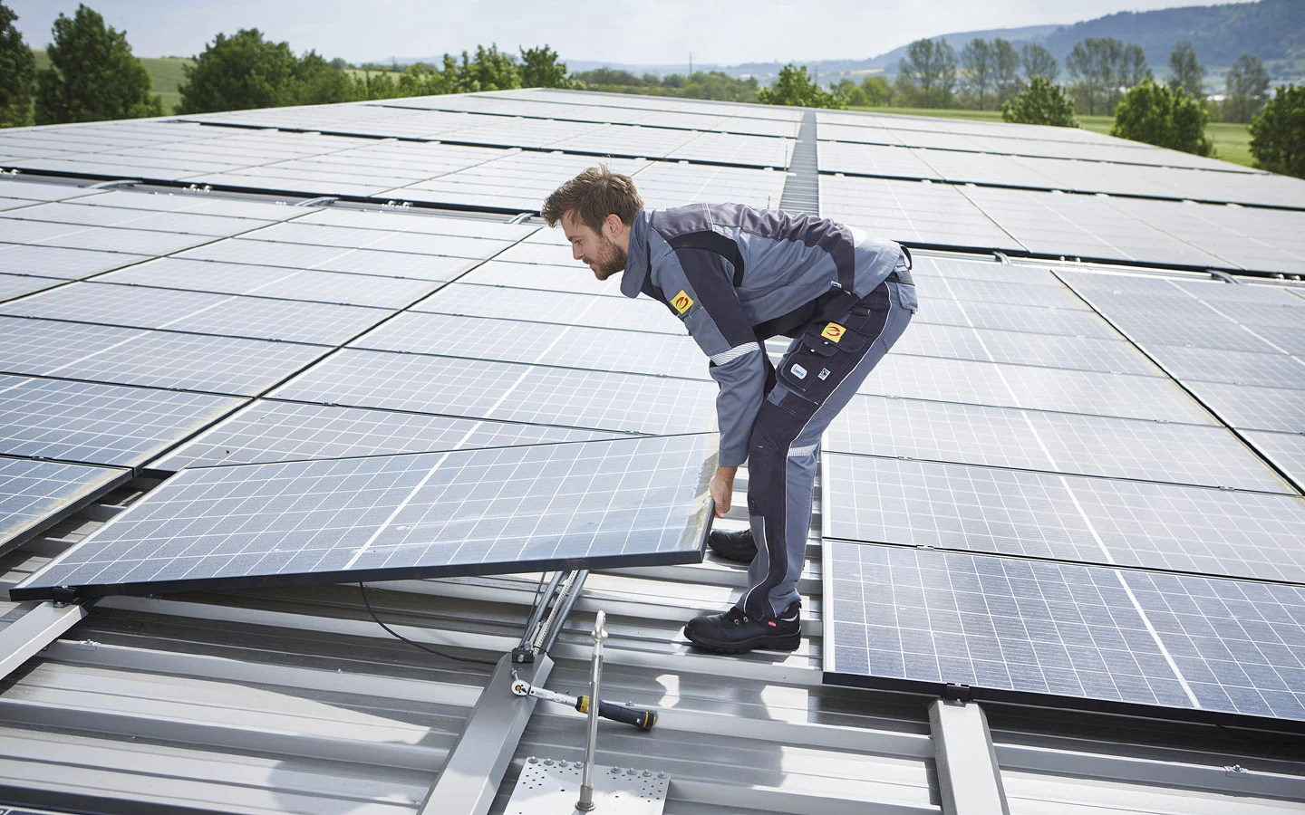 E-CHECK PV - Mitarbeiter installiert Solarzellen auf dem Dach · Finke Elektro